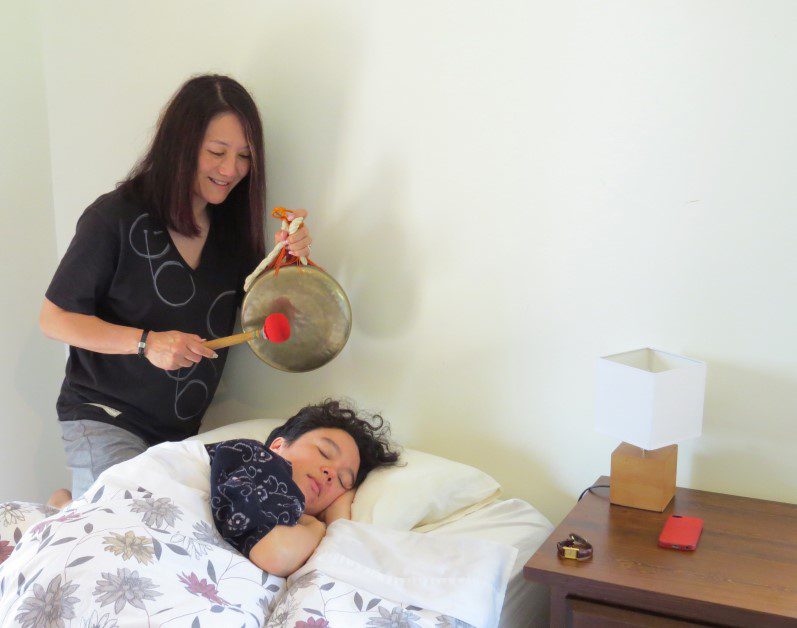 Gong waking a woman up in bed