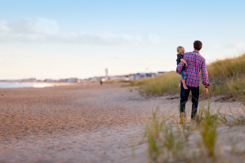 Man on beach with son